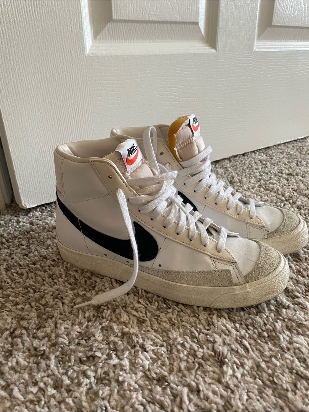 Nike White High-Top Sneakers with Black Swoosh and Orange Tongue Tab